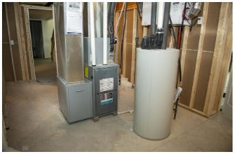 Hot water boiler and heating furnace installed in unfinished room.