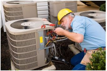 HVAC technician man working on AC units. There are a total of 4 units that he is working on.